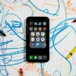 black iphone 4 on white and blue textile