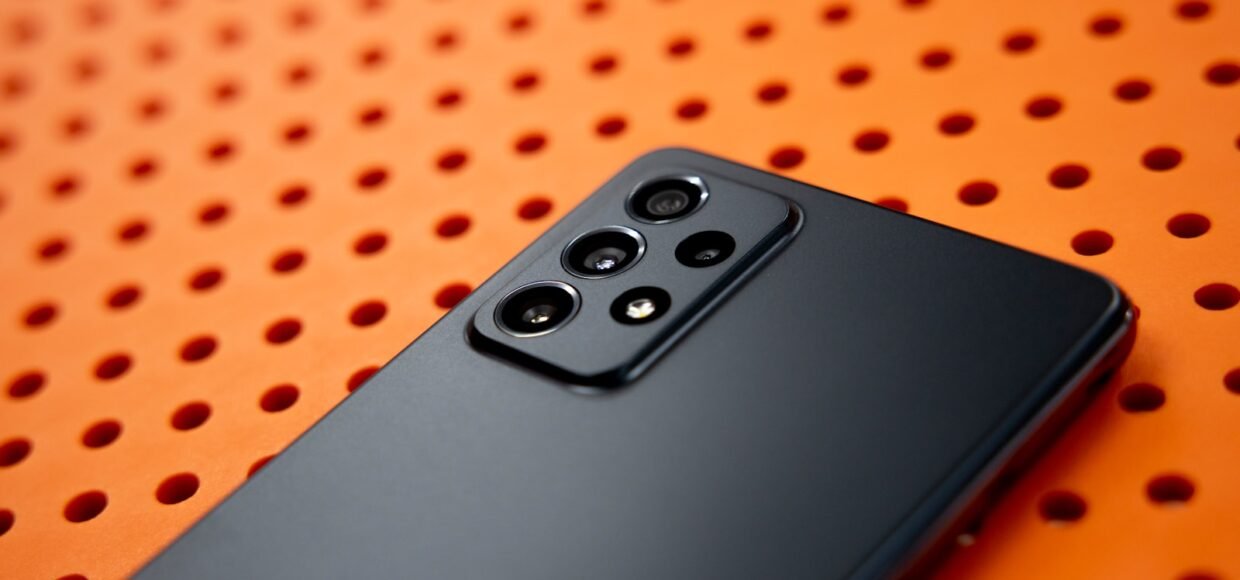 black remote control on orange and white polka dot textile